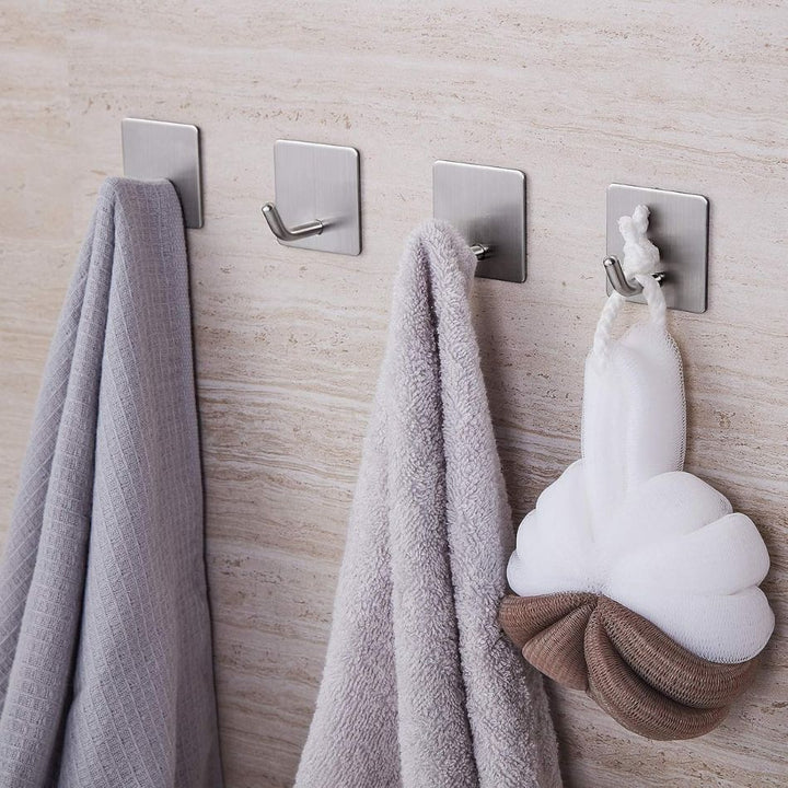 Crochet adhésif pour salle de bain en coloris argenté / acier inox brossé, 4 pièces accrochés au mur avec suspendu : 2 serviettes et une fleur de douche